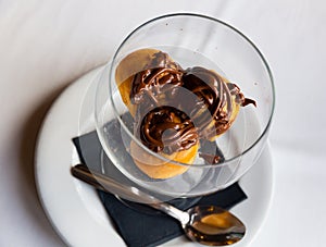 Cream profiteroles with hot chocolate photo