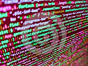 Program code - angle view Modern application Coded data on monitor. Lines of minificated JS code. Developer working on web sites