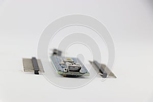 Programmable micro controller board with the unsoldered pins isolated on white background