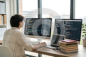 A programmer coding AI on a multi-monitor setup