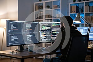 A programmer coding AI on a multi-monitor setup