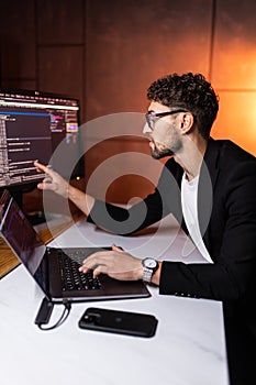 Programmer are coding on a laptop in the dark. The concept of a developer or hacker
