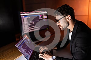 Programmer are coding on a laptop in the dark. The concept of a developer or hacker