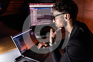Programmer are coding on a laptop in the dark. The concept of a developer or hacker