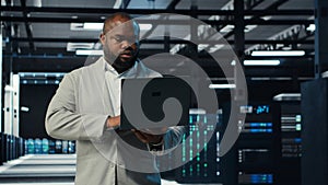 Programmer in data center using laptop, testing equipment failover scenarios