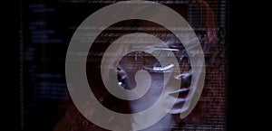 Programmer or Developer working in dark room with computer code reflected on their monitor