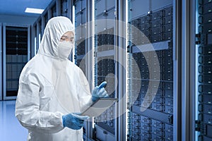 Programmer or engineer with tablet in server room