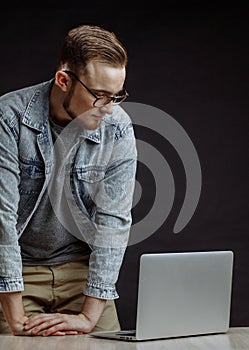 Programmer in fashin clothes standing and leaning on his palms