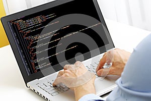 Programmer profession - man writing programming code on laptop