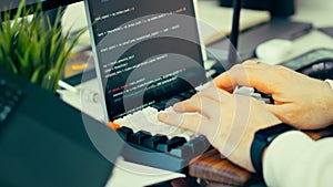 Programmer typing keyboard laptop screen source code