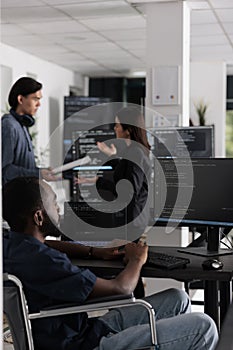 It programmer in wheelchair typing html code in coding office