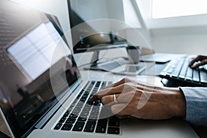 Programmer working On Computer In IT Office Typing Data Coding in software and checking code on computer screen