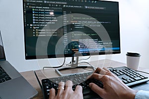 Programmer working On Computer In IT Office Typing Data Coding in software and checking code on computer screen