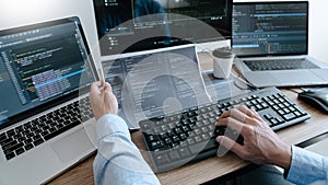 Programmer working On Computer In IT Office Typing Data Coding in software and checking code on computer screen