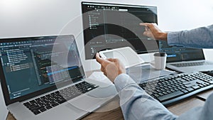 Programmer working On Computer In IT Office Typing Data Coding in software and checking code on computer screen