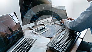 Programmer working On Computer In IT Office Typing Data Coding in software and checking code on computer screen