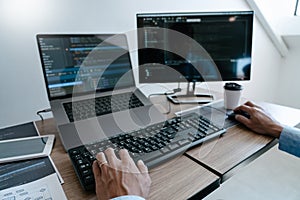 Programmer working On Computer In IT Office Typing Data Coding in software and checking code on computer screen