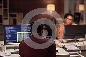 Programmer working on computers in office