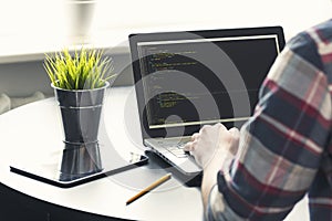 Programmer working on laptop at office