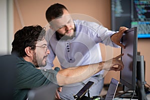 Programmers engrossed in deep collaboration, diligently working together to solve complex problems