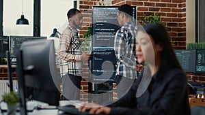 Programmers leaving after analyzing source code on wall screen tv comparing errors using digital tablet