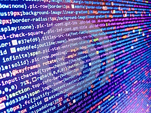Programming abstract - source code and binary code on display of software developer. Screen of web developing code on dark