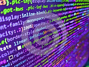 Programming code on computer monitor. Code on dark background. Abstract technology background. Young business crew working with