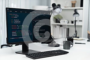 Programming code on computer screen desktop placing on working desk. Infobahn.