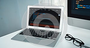 Programming code on laptop monitor and beside screen pc desktop. Tastemaker.