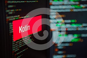 Programming language, Kotlin inscription on the background of computer code.