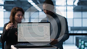 Programming language on notebook used by server room IT experts, close up