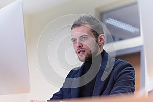 Programming. Man working on computer in it office, sitting at desk writing codes. Programmer typing data code, working on project