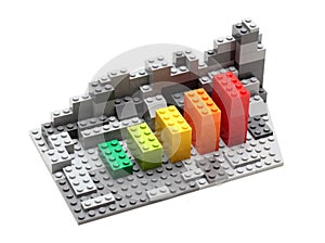 Progress chart made of bricks. Isometric composition of colourful toys on white table.