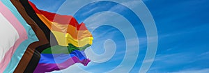 Progress LGBTQ rainbow flag waving in the wind at cloudy sky. Freedom and love concept. Pride month. activism, community and