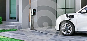 Progressive concept of EV car and home charging station in residential area.