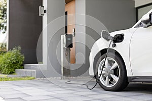 Progressive concept of EV car and home charging station in residential area.