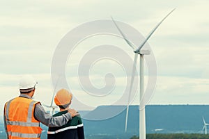 Progressive engineer with his son in the wind farm atop of the mountain.