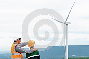 Progressive engineer with his son in the wind farm atop of the mountain.