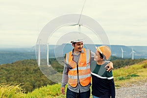 Progressive engineer with his son in the wind farm atop of the mountain.