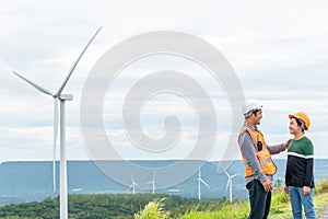 Progressive engineer with his son in the wind farm atop of the mountain.