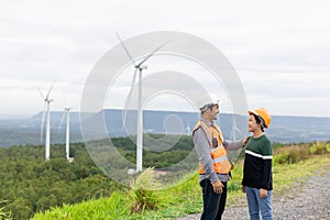 Progressive engineer with his son in the wind farm atop of the mountain.