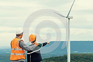 Progressive engineer with his son in the wind farm atop of the mountain.