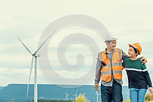 Progressive engineer with his son in the wind farm atop of the mountain.