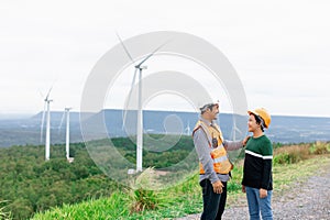 Progressive engineer with his son in the wind farm atop of the mountain.