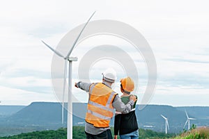 Progressive engineer with his son in the wind farm atop of the mountain.