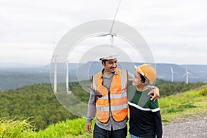 Progressive engineer with his son in the wind farm atop of the mountain.