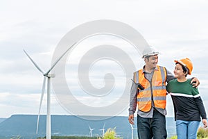 Progressive engineer with his son in the wind farm atop of the mountain.