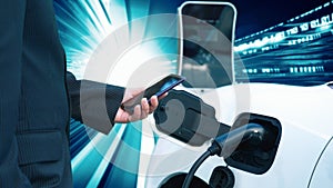 Progressive man charge electric car with technology background of binary code.