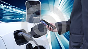 Progressive man charge electric car with technology background of binary code.