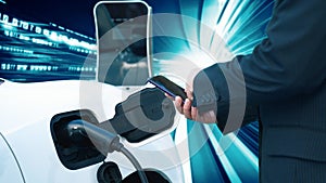 Progressive man charge electric car with technology background of binary code.